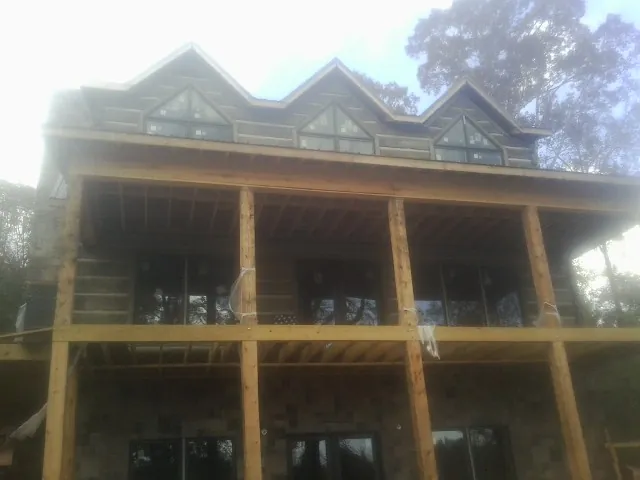 Dormers and porch framing on a large log home under construction — Roof Coating work by our crew in Leadore