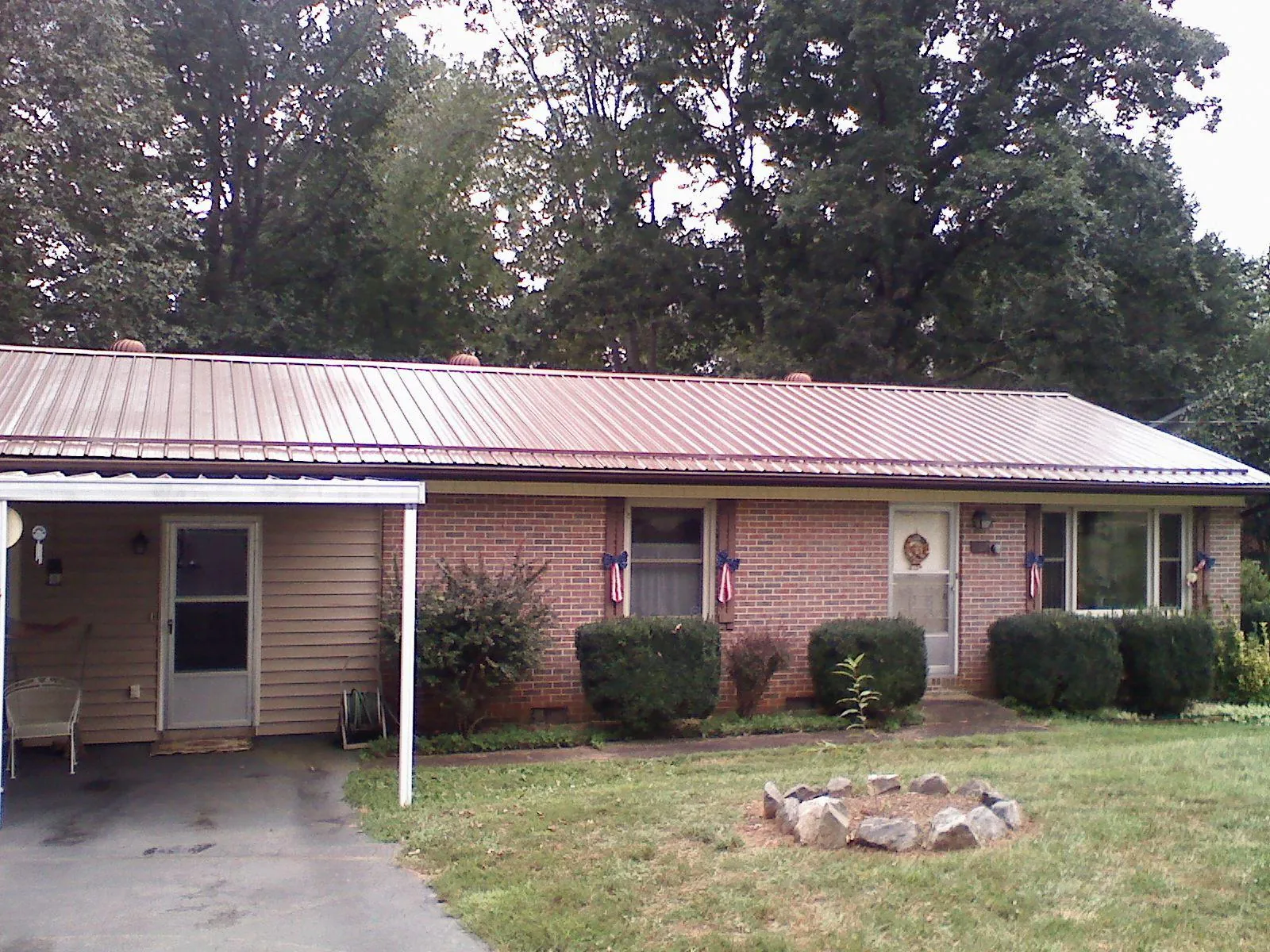 Bronze metal roof and carport on a brick ranch home — Roof Repair work by our crew in Leadore
