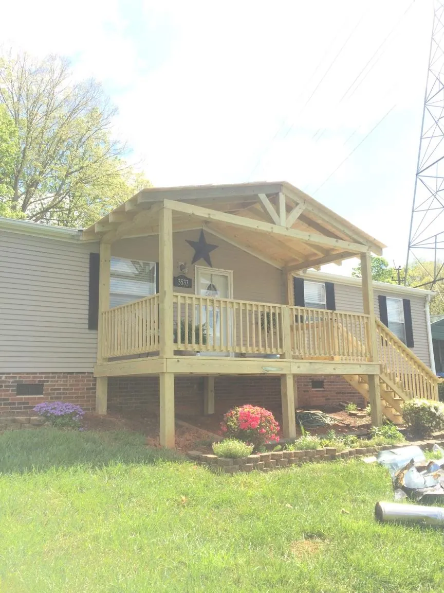 New gabled porch roof and deck railing added to a ranch home in Leadore